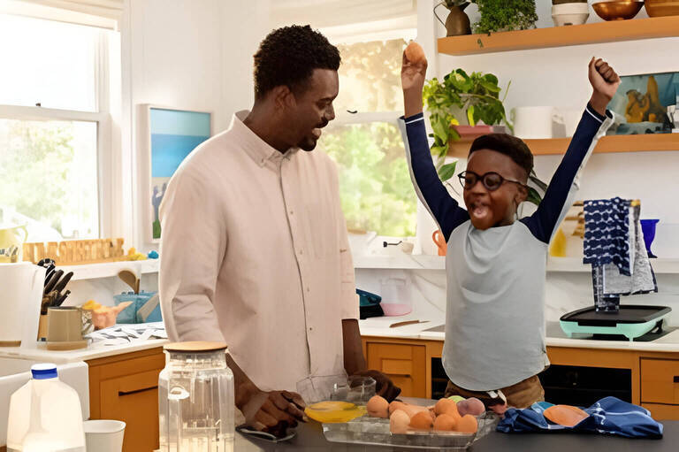 Father and son laughing in the kitchen